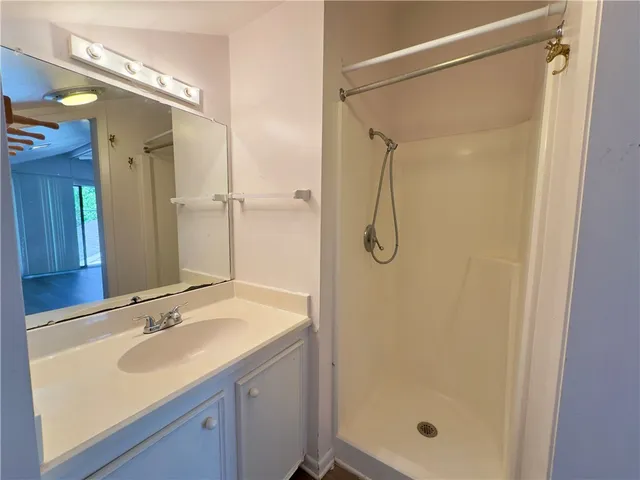 a bathroom with a shower sink and mirror
