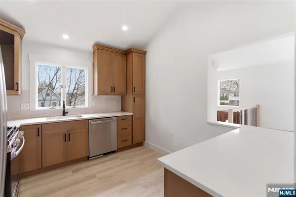 a large white kitchen with sink and cabinets