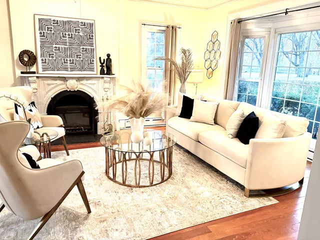 a living room with furniture large window and fireplace