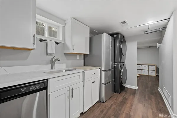 a kitchen with white cabinets and sink