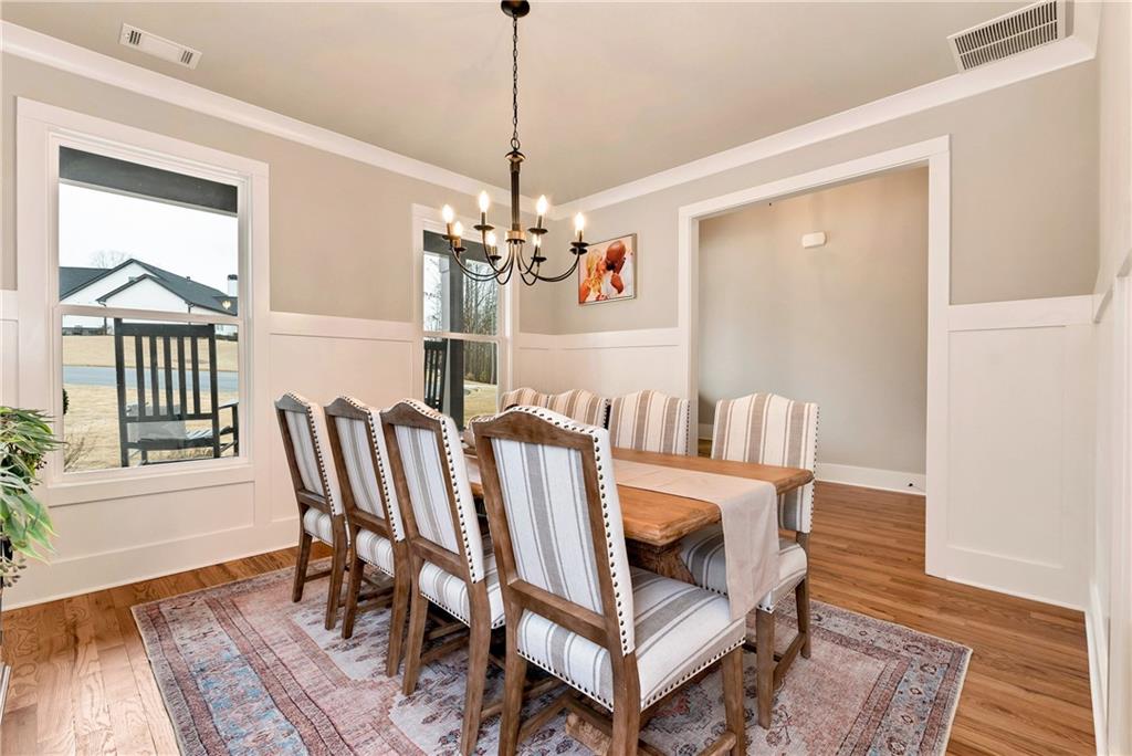 6140 Crescent Moon Ridge Cumming, GA 30041 - Photo 13 of 54 a view of a dining room with furniture wooden floor and a chandelier