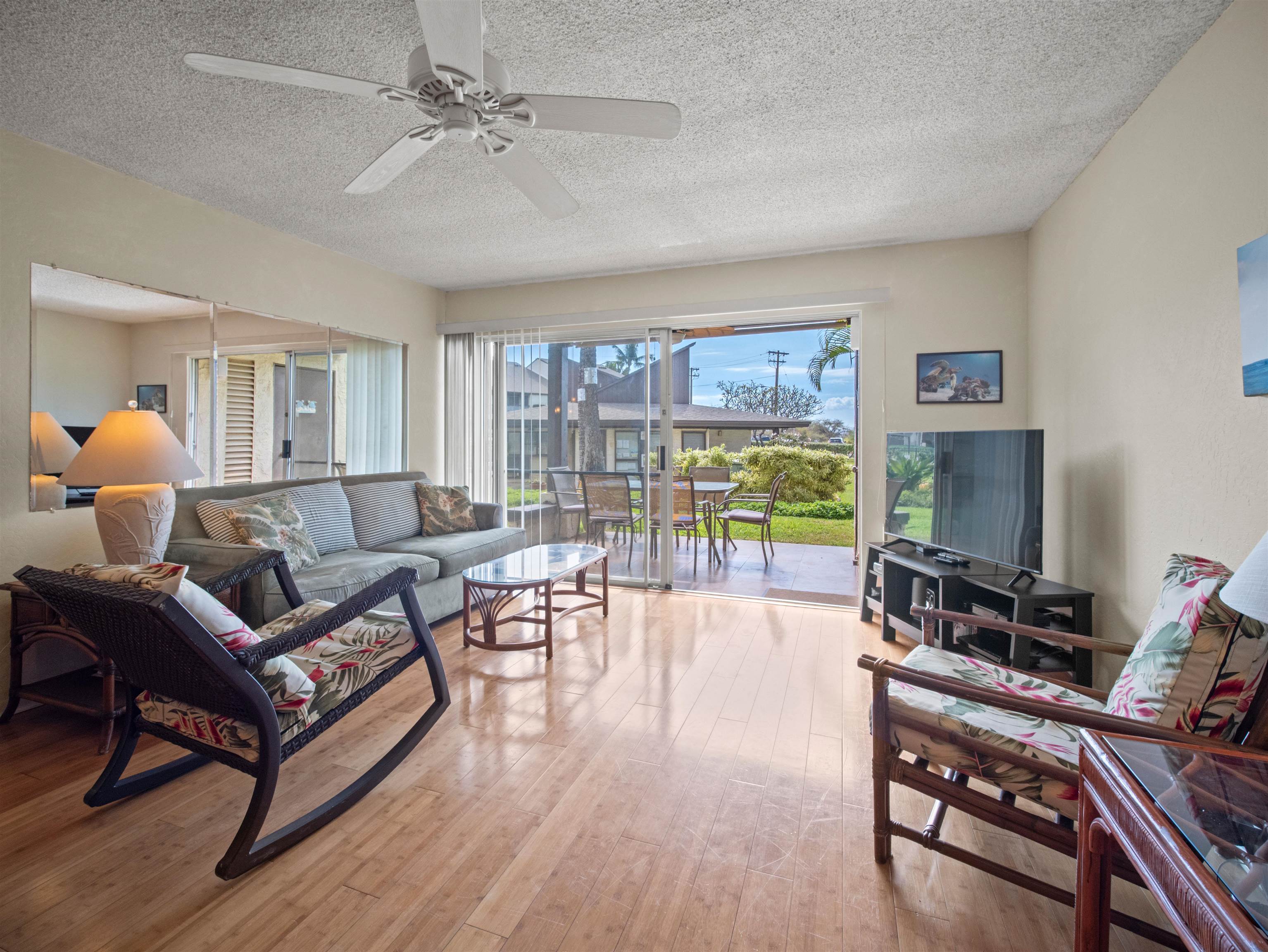 2737 South Kihei Road, Unit 1106 Kihei, HI 96753 - Photo 12 of 25 a living room with furniture a flat screen tv and a large window