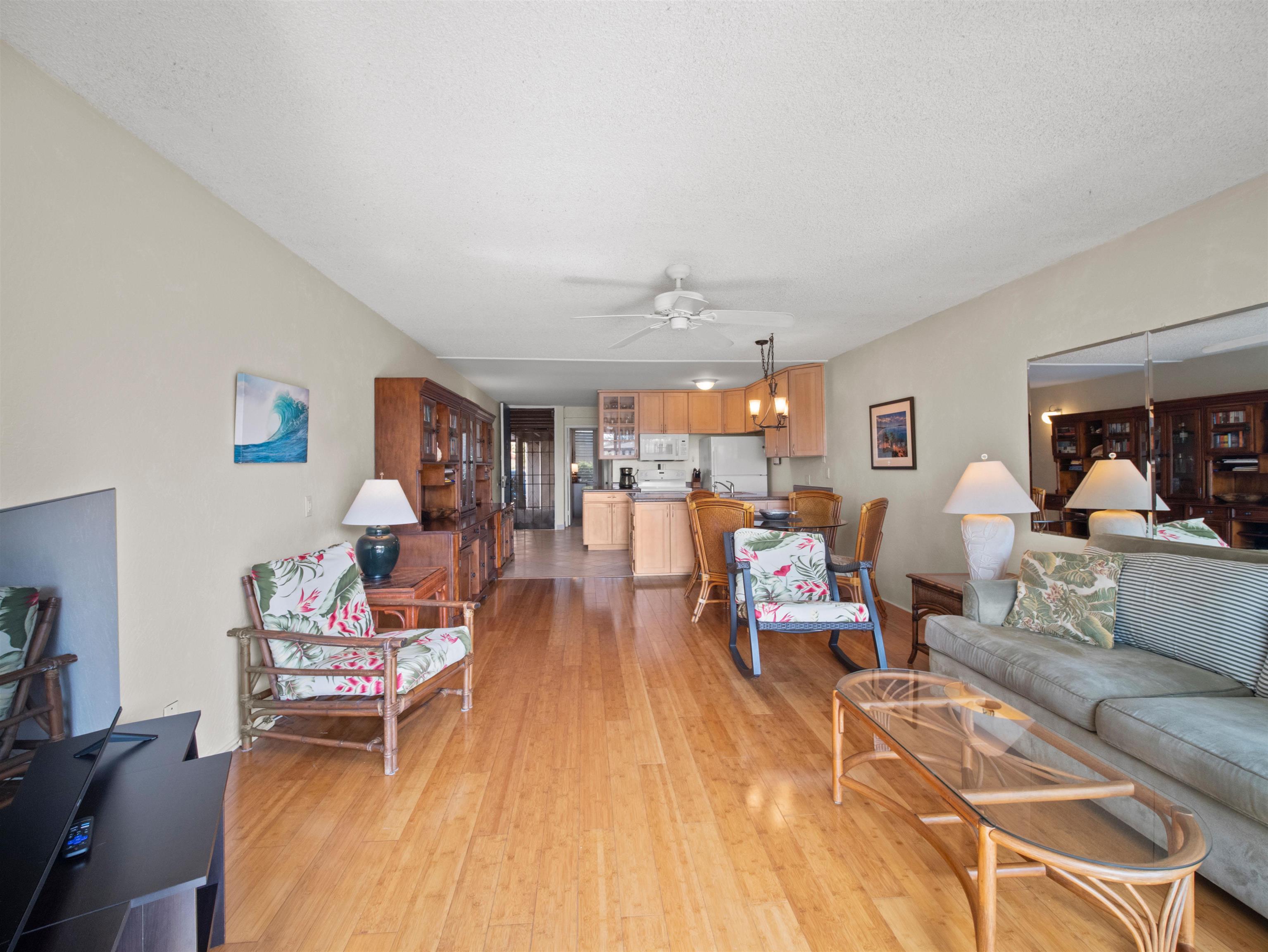 2737 South Kihei Road, Unit 1106 Kihei, HI 96753 - Photo 7 of 25 a living room with furniture and a wooden floor