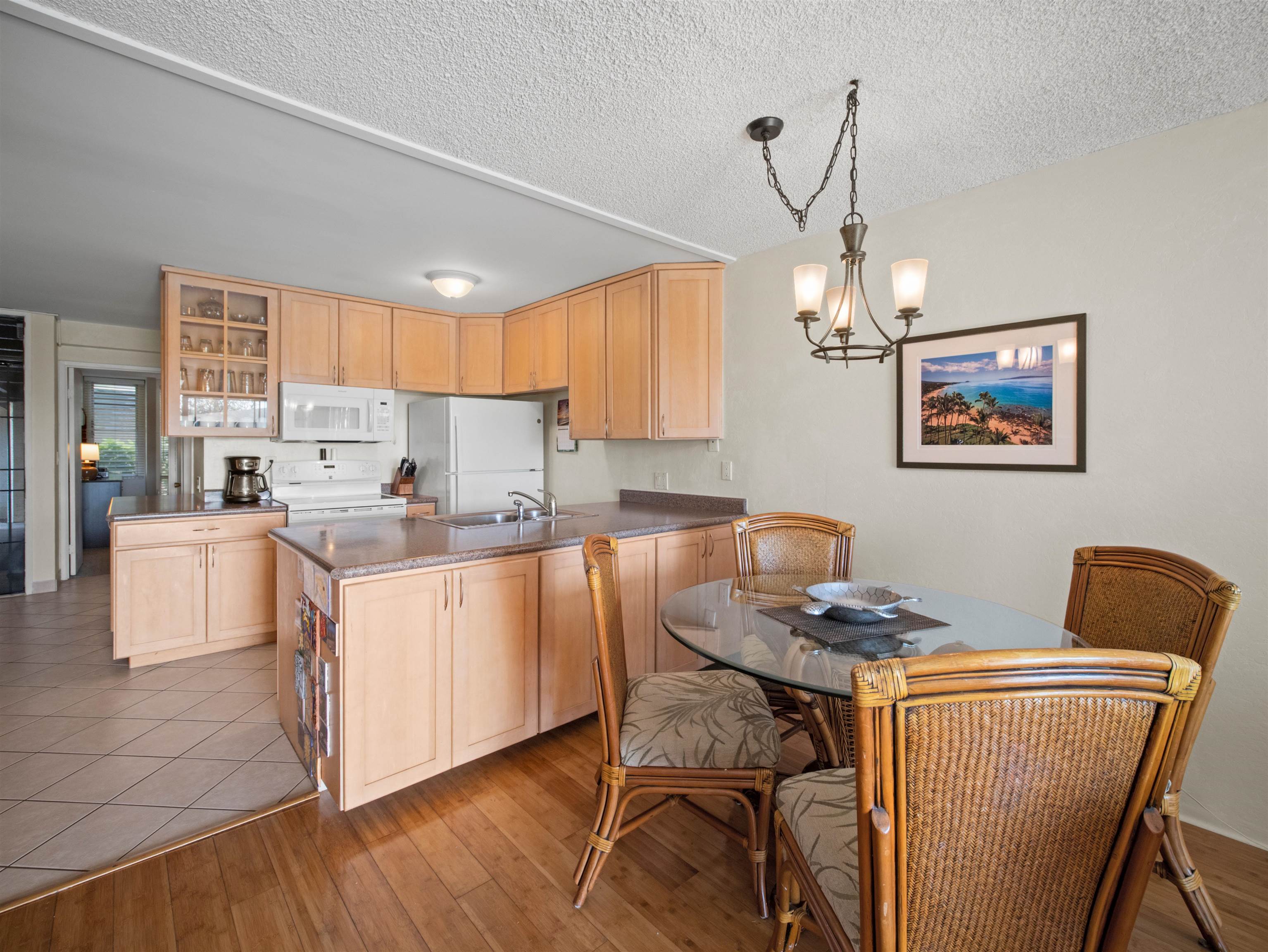 2737 South Kihei Road, Unit 1106 Kihei, HI 96753 - Photo 8 of 25 a kitchen with granite countertop white cabinets and white appliances