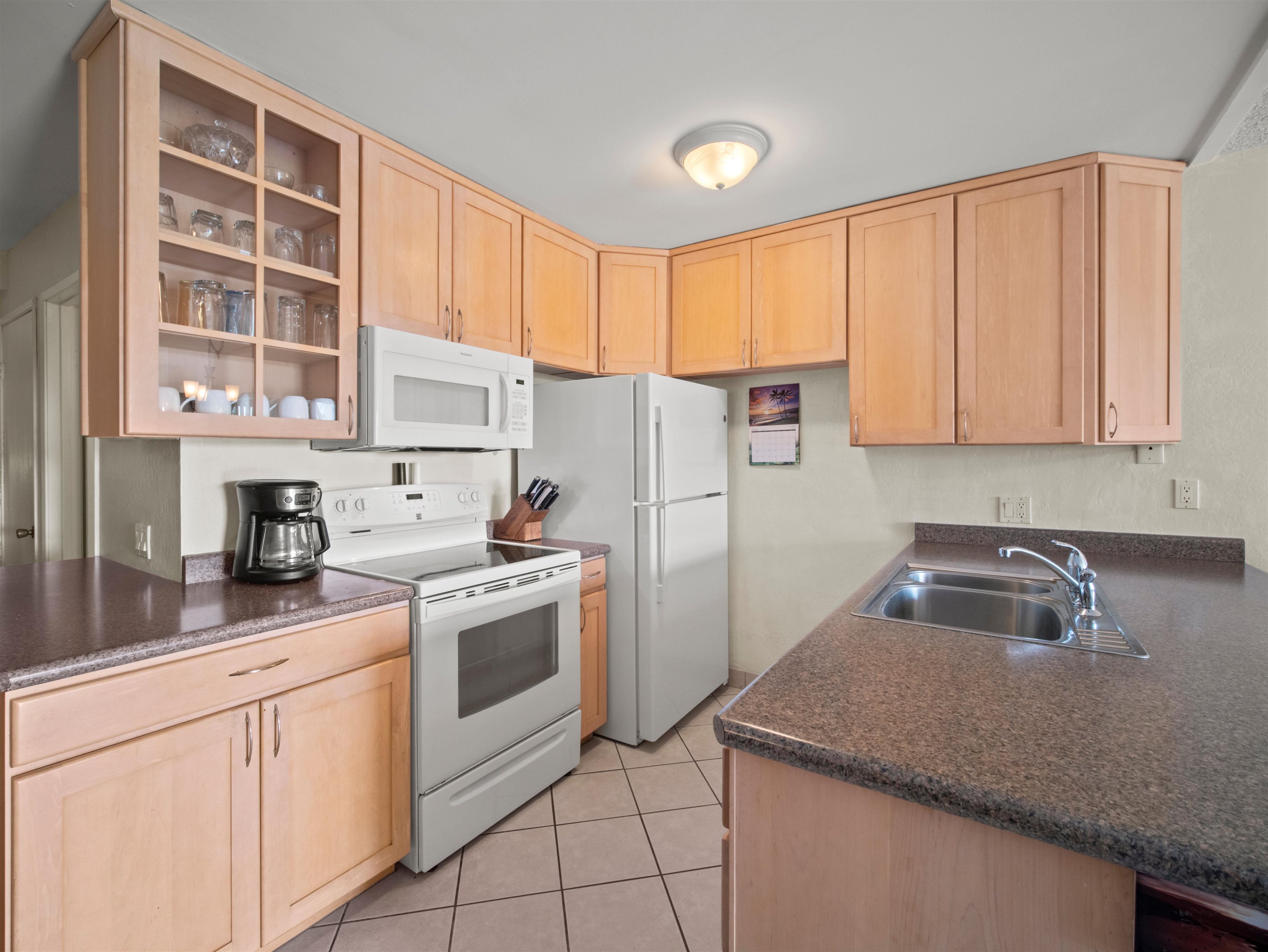 2737 South Kihei Road, Unit 1106 Kihei, HI 96753 - Photo 9 of 25 a kitchen with a sink a stove and cabinets