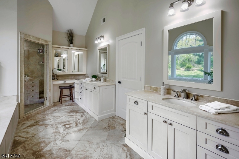 85 Mosle Road Peapack-Gladstone, NJ 07931 - Photo 33 of 49 a spacious bathroom with a granite countertop sink mirror and a bathtub