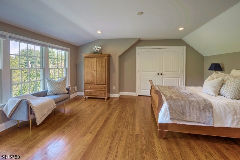 85 Mosle Road Peapack-Gladstone, NJ 07931 - Photo 39 of 49 a spacious bedroom with a large bed and a wooden floor