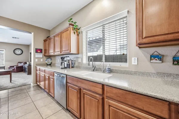a view of a kitchen with kitchen island stainless steel appliances a sink stove and cabinets