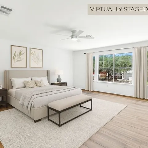 a spacious bedroom with a bed and large window