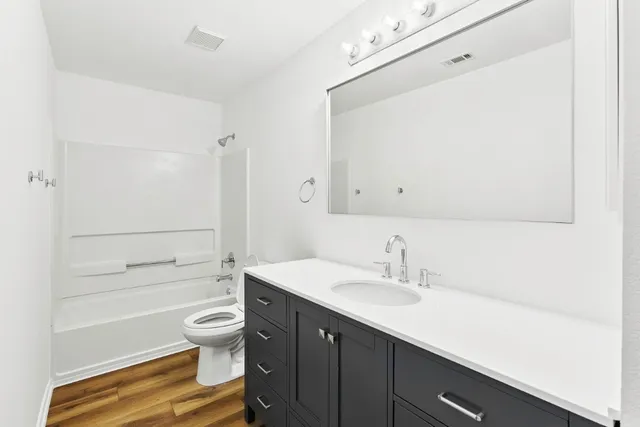 a bathroom with a sink a toilet a tub and shower