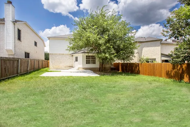a view of a house with backyard and sitting area