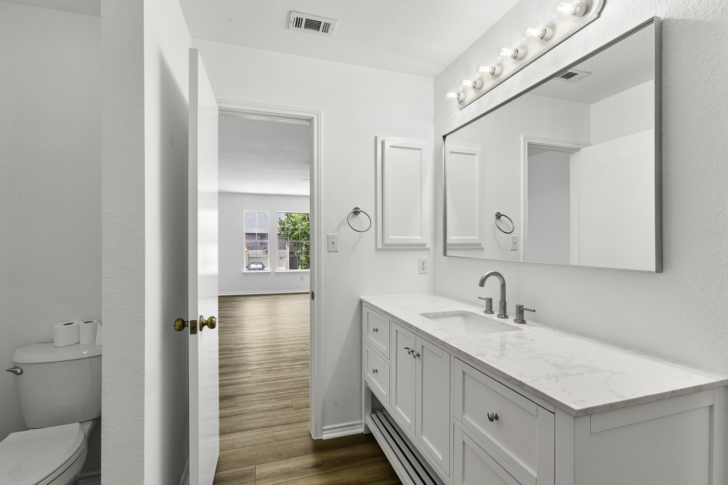 2431 Lavendale Court Austin, TX 78748 - Photo 3 of 22 Freshly painted primary bathroom featuring new vanities, LVP flooring, mirrors, hardware, tiled shower and toilet
