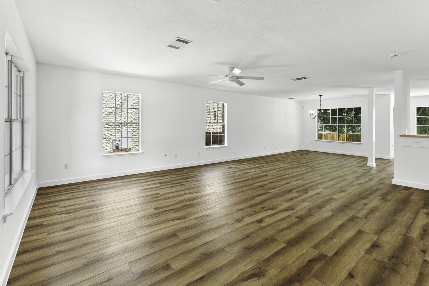 2431 Lavendale Court Austin, TX 78748 - Photo 4 of 22 Freshly painted living room featuring lots of natural light, along with new LVP flooring, ceiling fan, and lighting.