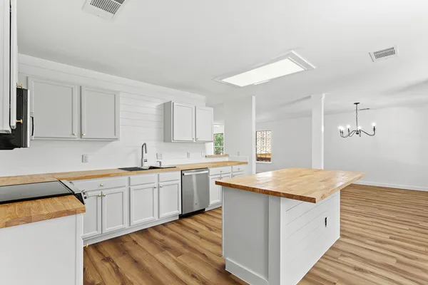 a kitchen with granite countertop white cabinets and white appliances