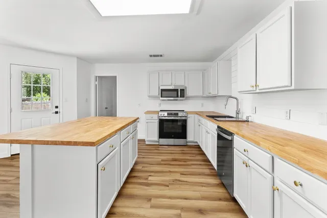 a large kitchen with granite countertop lots of counter top space and wooden floor