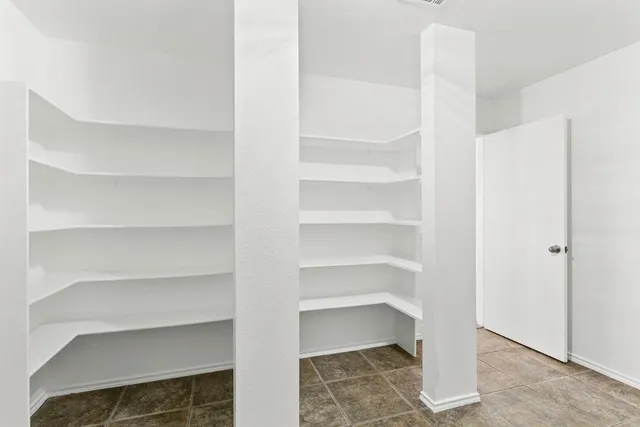 a view of walk in closet with empty racks