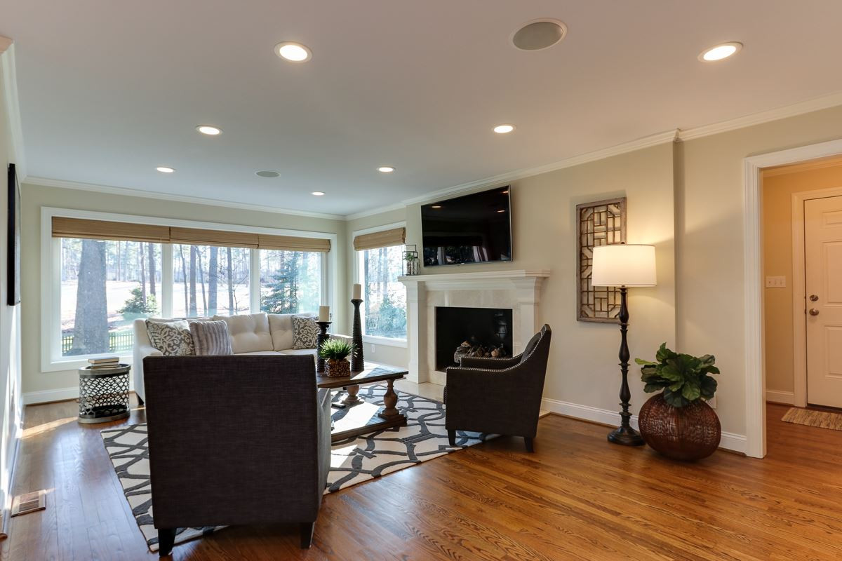 7009 North Ridge Drive Raleigh, NC 27615 - Photo 5 of 25 Family room has wall of windows overlooking golf course, masonry fireplace with gas logs, hardwood floors, built-in bookcase, and open to kitchen. Family Room
