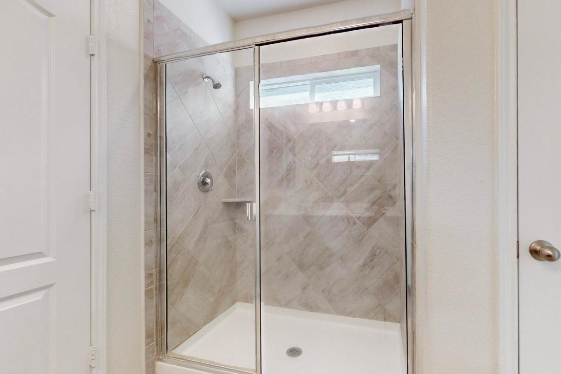 17308 Crazy Arm Road Round Rock, TX 78664 - Photo 11 of 22 a bathroom with a glass shower door