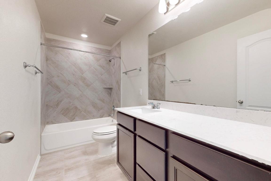 17308 Crazy Arm Road Round Rock, TX 78664 - Photo 13 of 22 a bathroom with a sink a toilet and shower