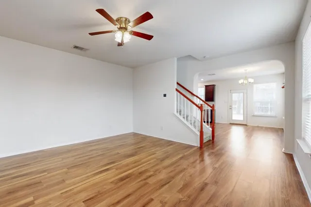 a large kitchen with a center island wooden floor stainless steel appliances and cabinets