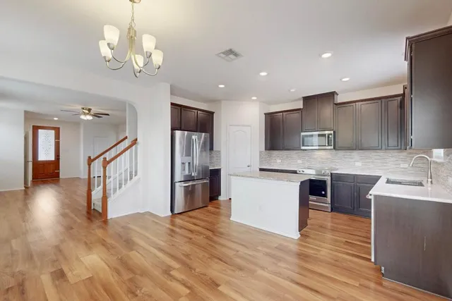 a kitchen with stainless steel appliances granite countertop a sink stove and refrigerator