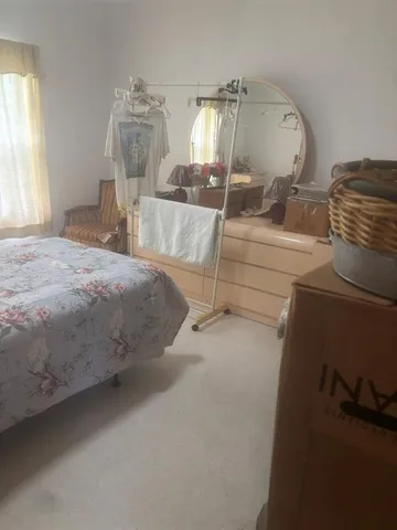 a room with a bed mirror and a window