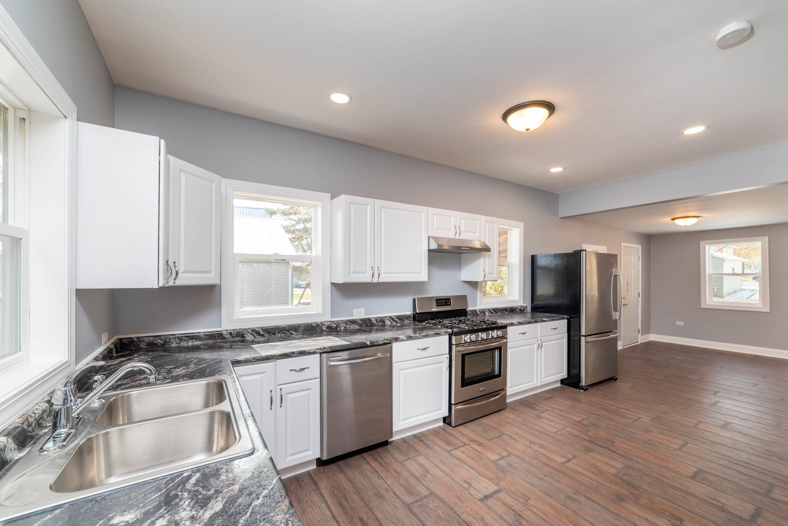 404 Garfield Road Harvard, IL 60033 - Photo 2 of 30 a kitchen with granite countertop stainless steel appliances a sink cabinets and a window