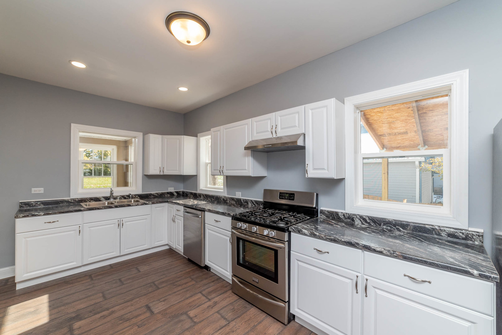 404 Garfield Road Harvard, IL 60033 - Photo 3 of 30 a kitchen with granite countertop stainless steel appliances a sink stove and cabinets