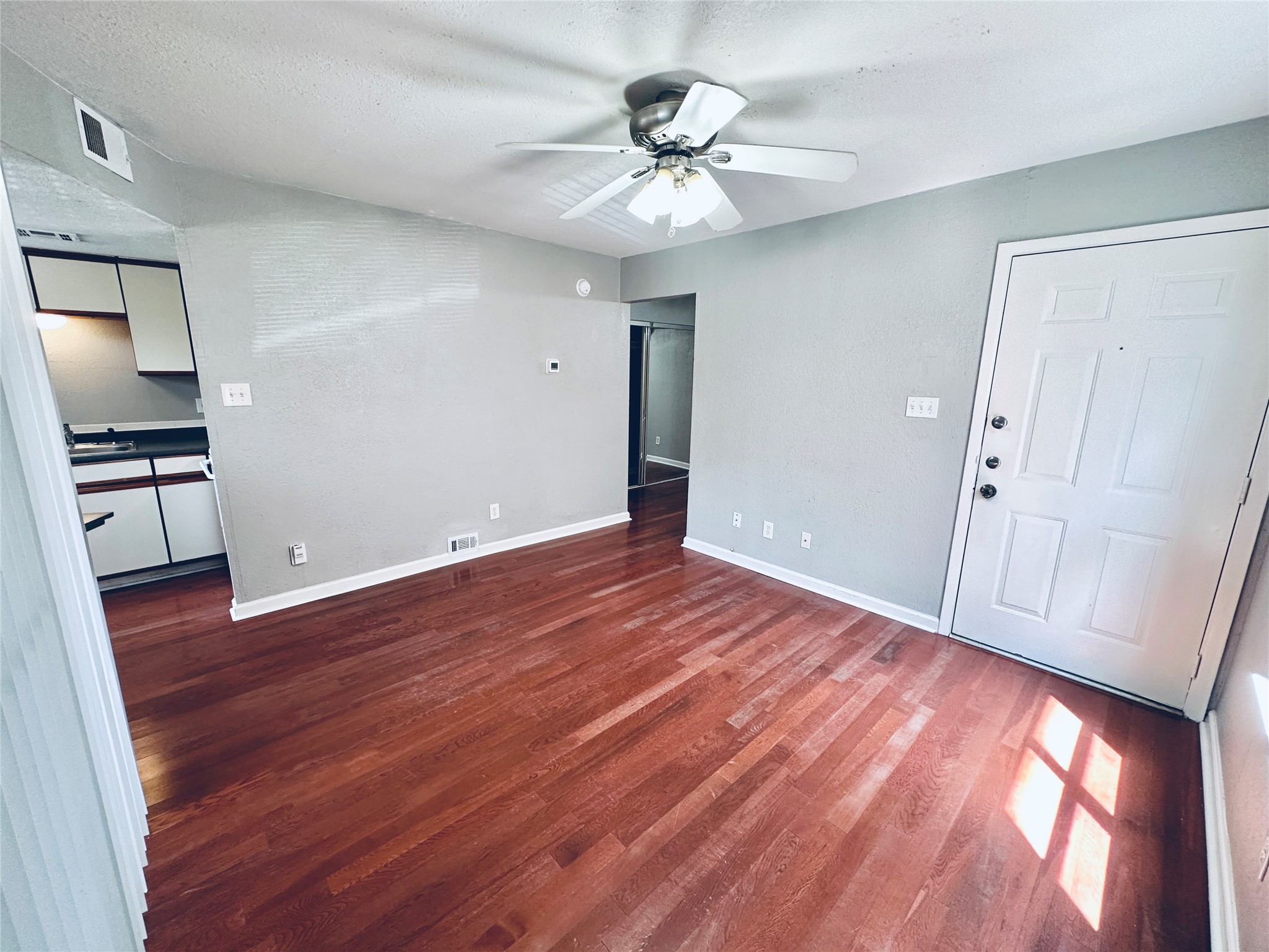 Rich hardwood flooring creates a warm and inviting atmosphere in this open living area.