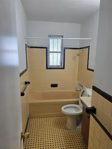 a bathroom with a sink a toilet a window and shower