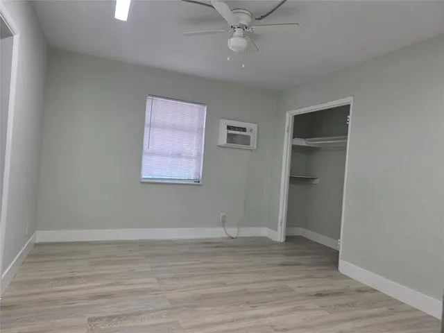 an empty room with wooden floor and closet