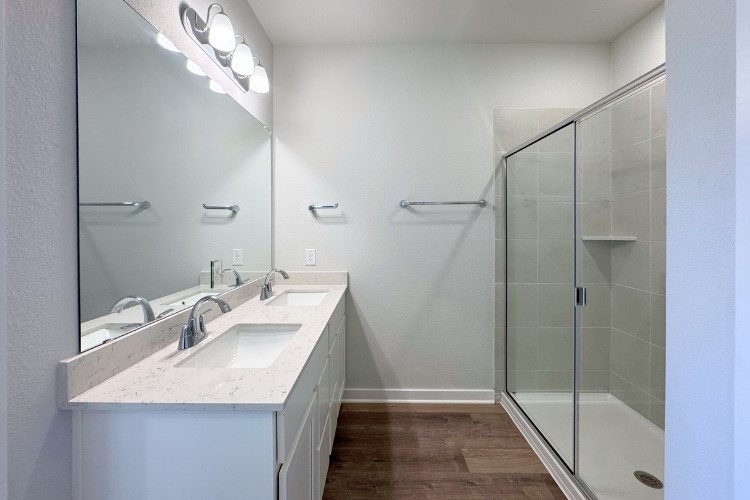 213 Firefox Way Jarrell, TX 76537 - Photo 5 of 12 a bathroom with a granite countertop sink a mirror and shower