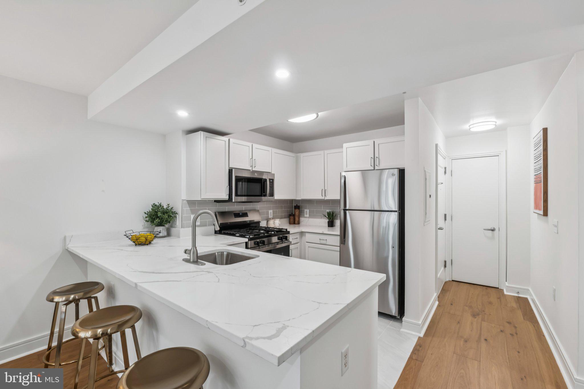 800 4th Street Southwest, Unit 121S Washington, DC 20024 - Photo 3 of 23 a kitchen that has a refrigerator a stove a microwave and dining table