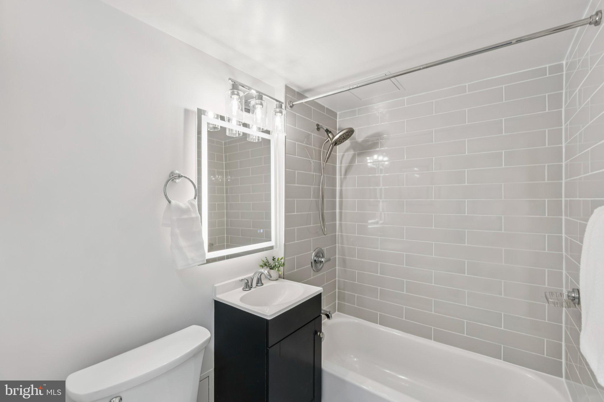 800 4th Street Southwest, Unit 121S Washington, DC 20024 - Photo 8 of 23 a bathroom with a shower a mirror and a sink