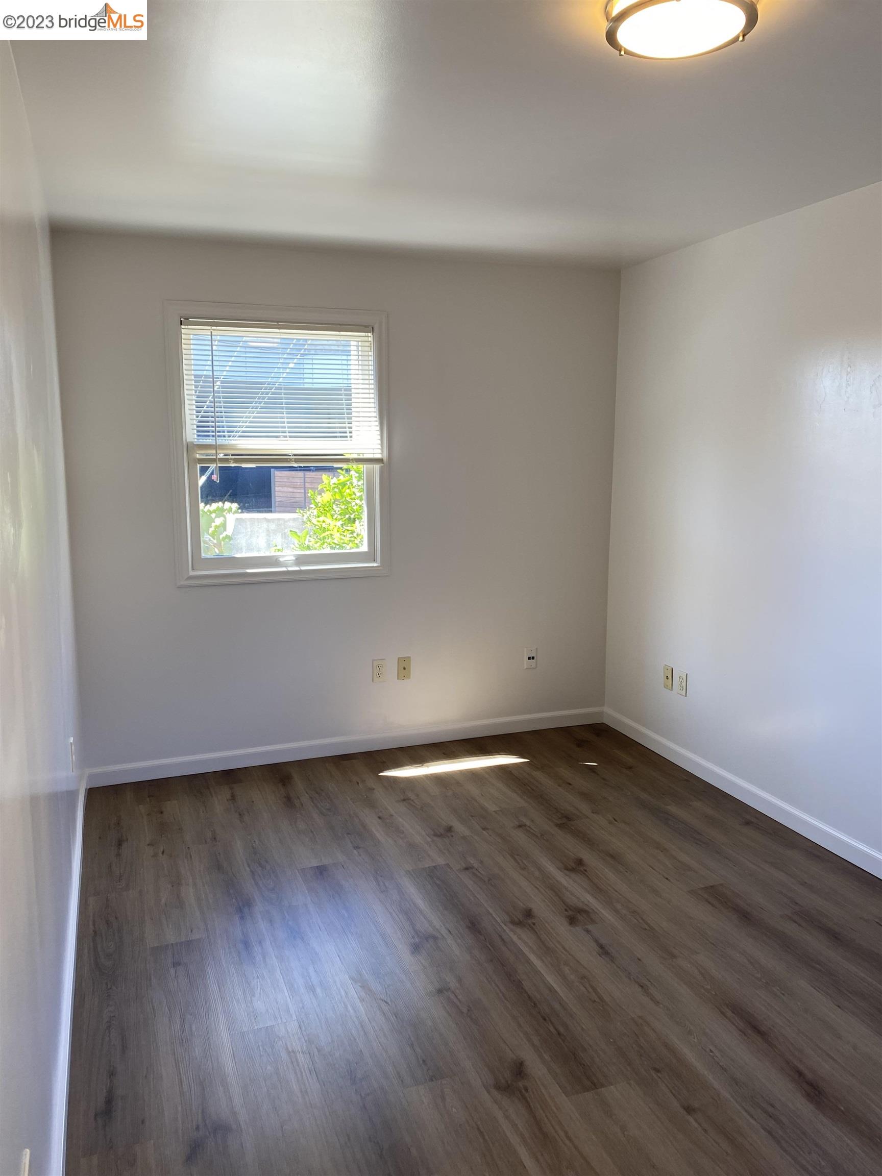 Rockridge Oakland, CA 94609 - Photo 11 of 31 a view of an empty room with wooden floor and a window