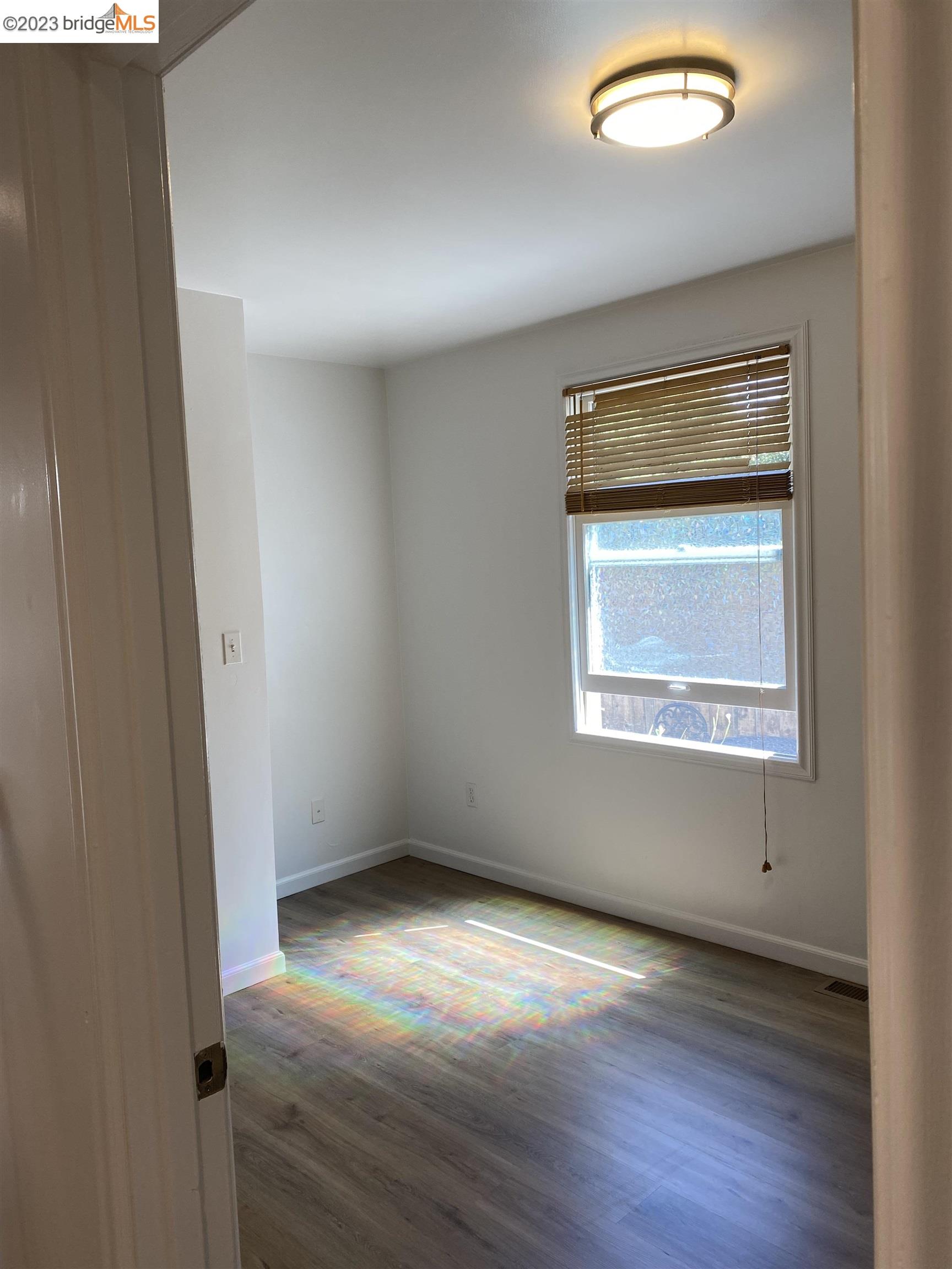 Rockridge Oakland, CA 94609 - Photo 14 of 31 an empty room with wooden floor and windows