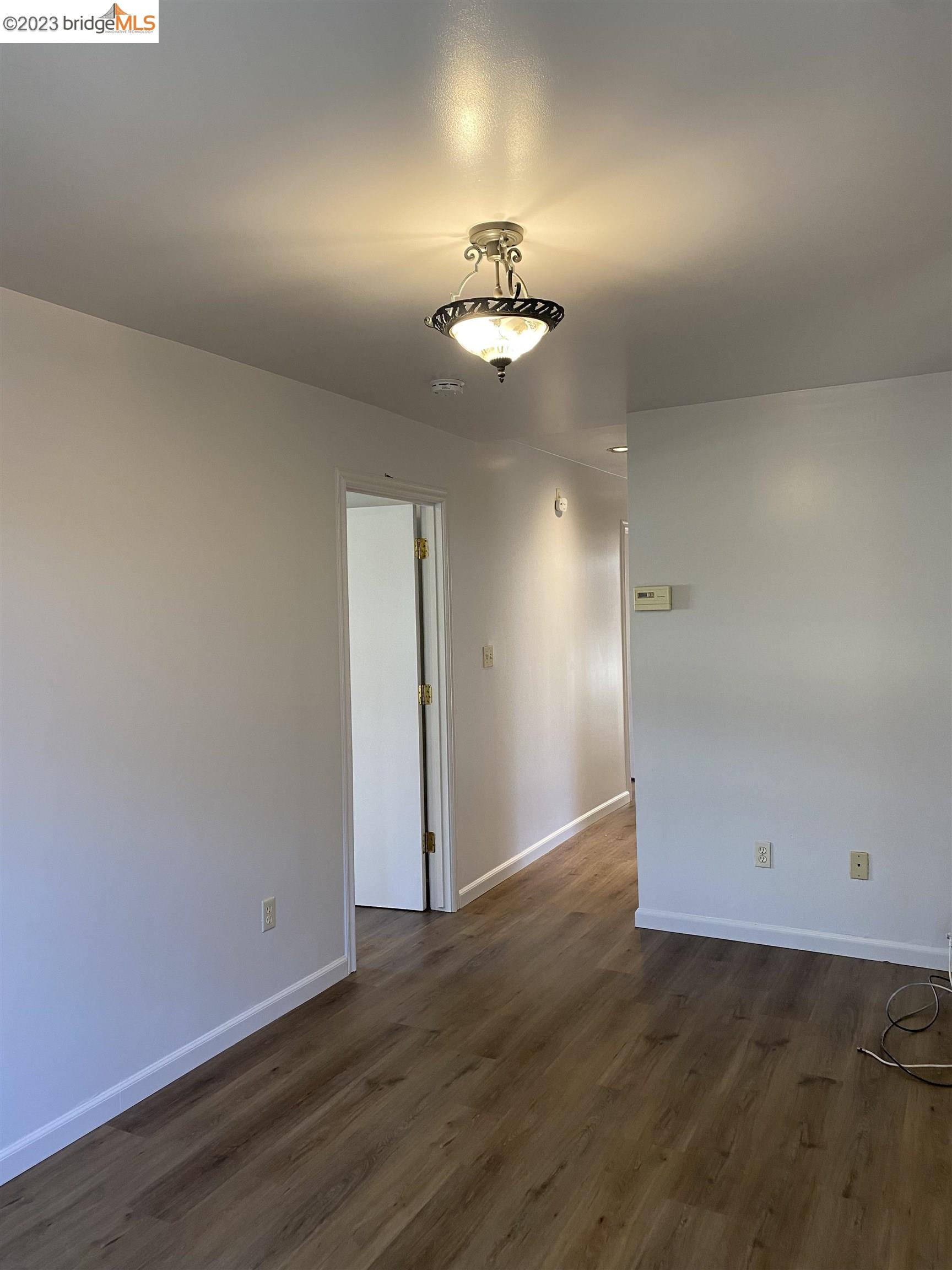 Rockridge Oakland, CA 94609 - Photo 8 of 31 an empty room with wooden floor chandelier fan and closet area