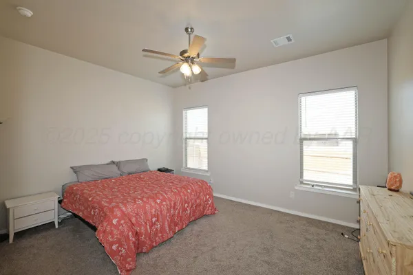 a bedroom with a bed and a ceiling fan