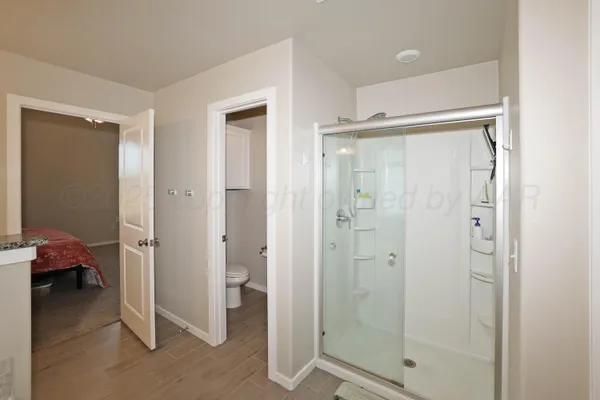 a en suite bathroom with a granite countertop sink and a mirror
