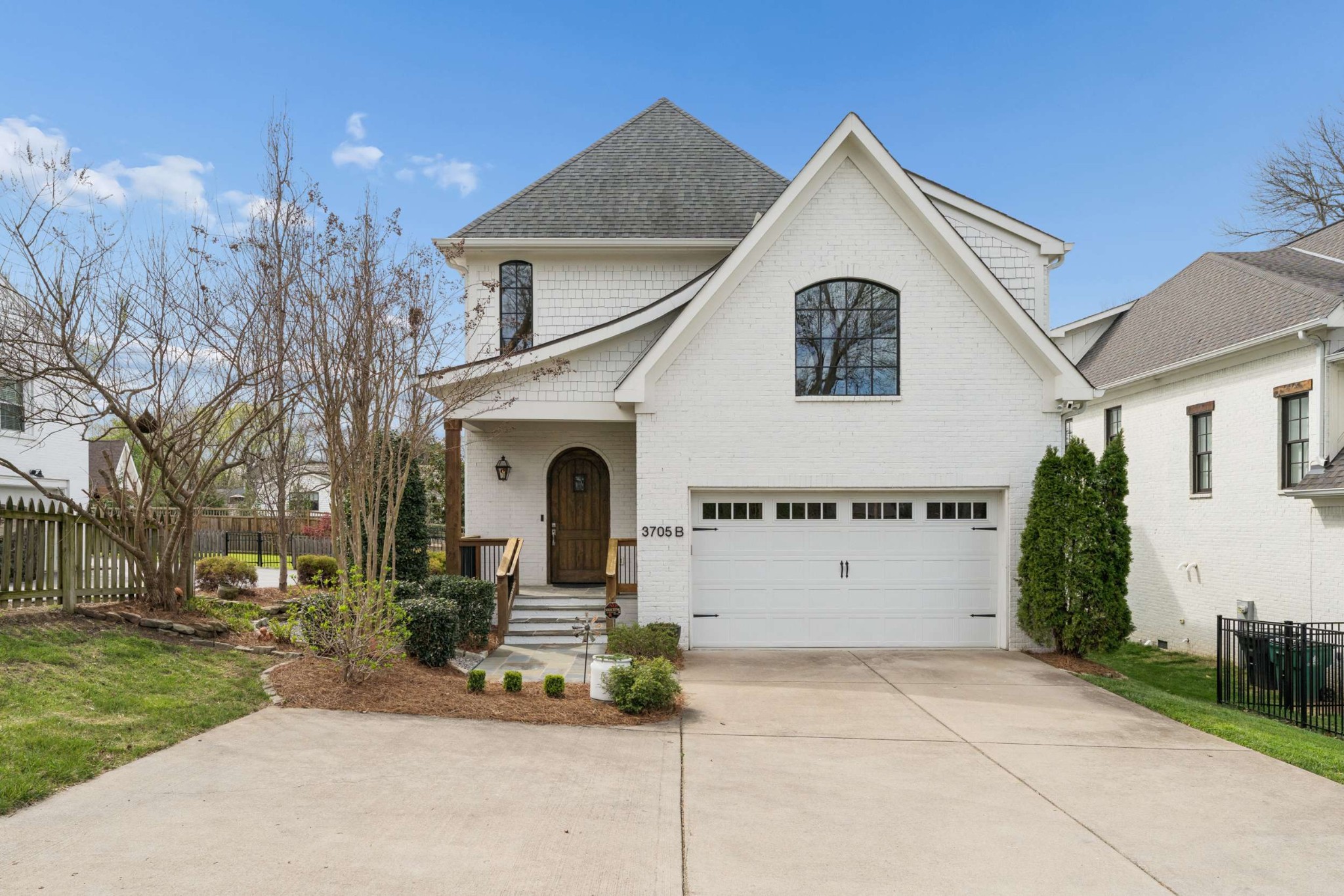 a view of white house with a yard and potted plants
