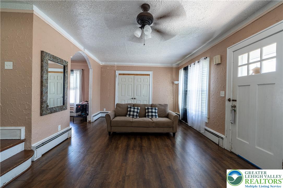 118 South 3rd Street Bangor, PA 18013 - Photo 5 of 33 This inviting living space features warm flooring, elegant crown molding, and an arched entryway.