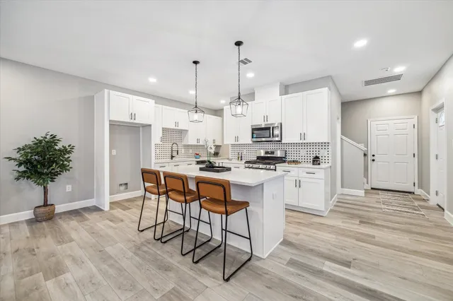 a kitchen with white cabinets and stainless steel appliances