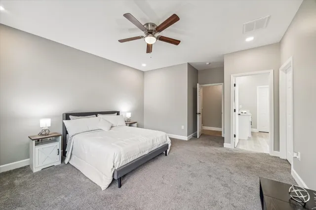 a bedroom with a large bed and a ceiling fan