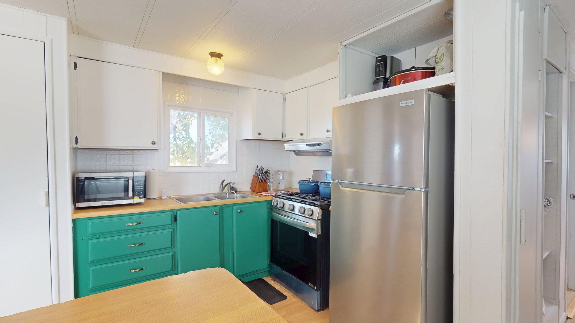 57775 Junipero Trail Yucca Valley, CA 92284 - Photo 5 of 19 a kitchen with a refrigerator sink and cabinets