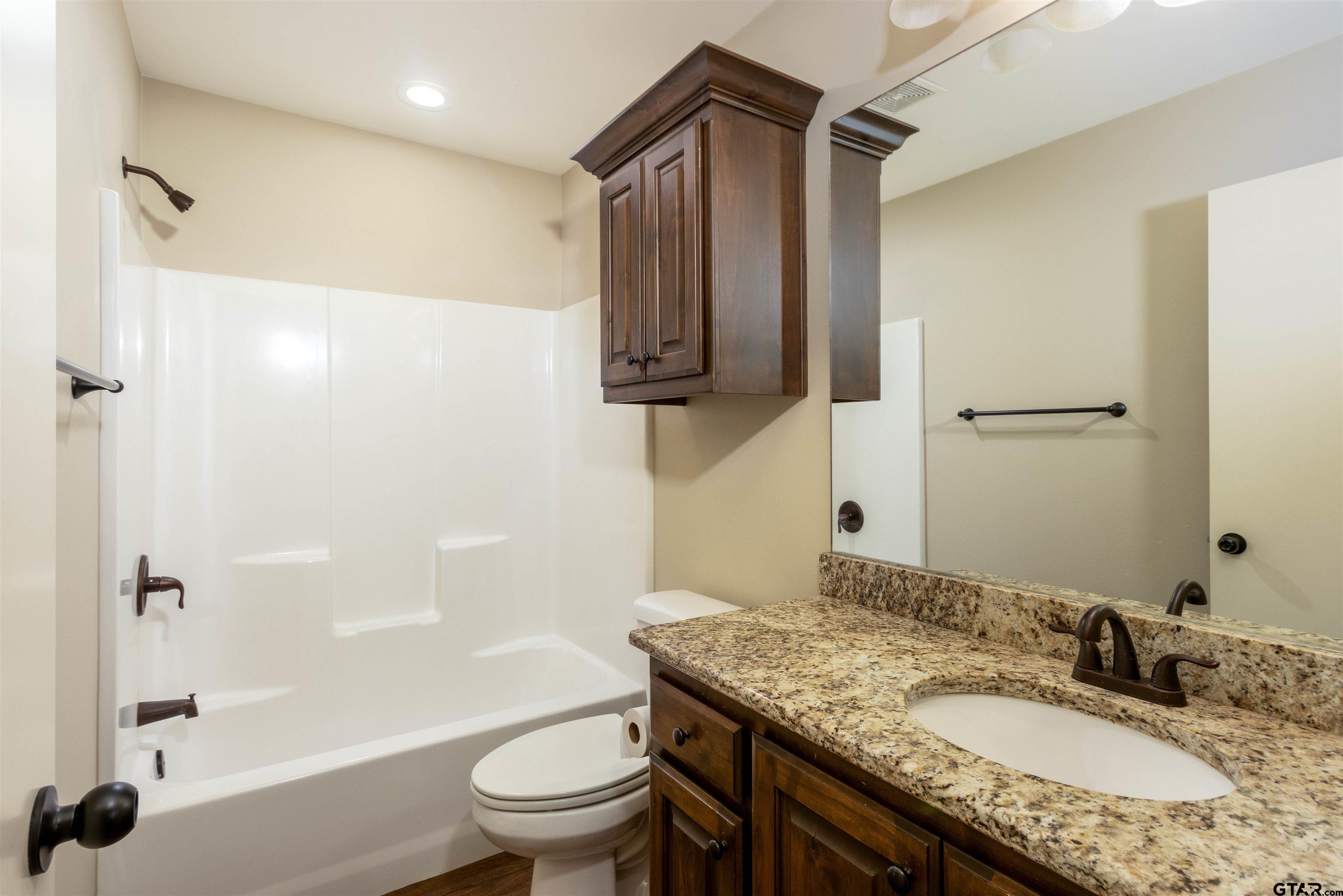 5106 Shiloh Ridge Drive Tyler, TX 75703 - Photo 11 of 19 a bathroom with a granite countertop sink toilet and shower