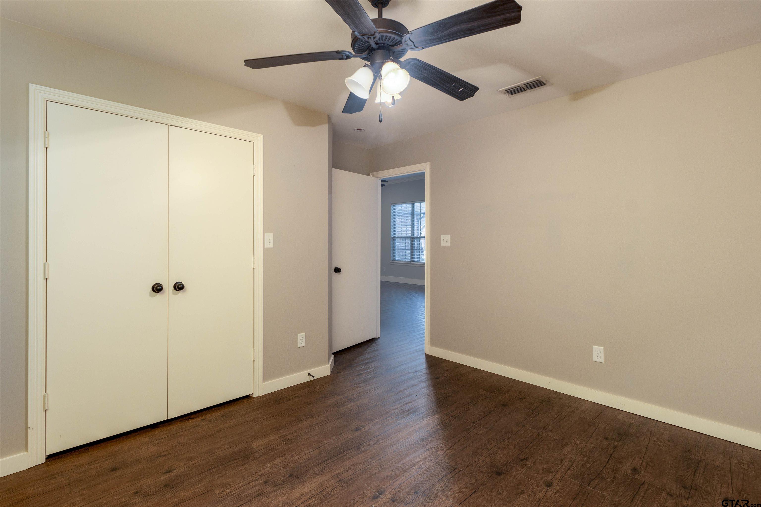 5106 Shiloh Ridge Drive Tyler, TX 75703 - Photo 13 of 19 an empty room with wooden floor a ceiling fan and closet