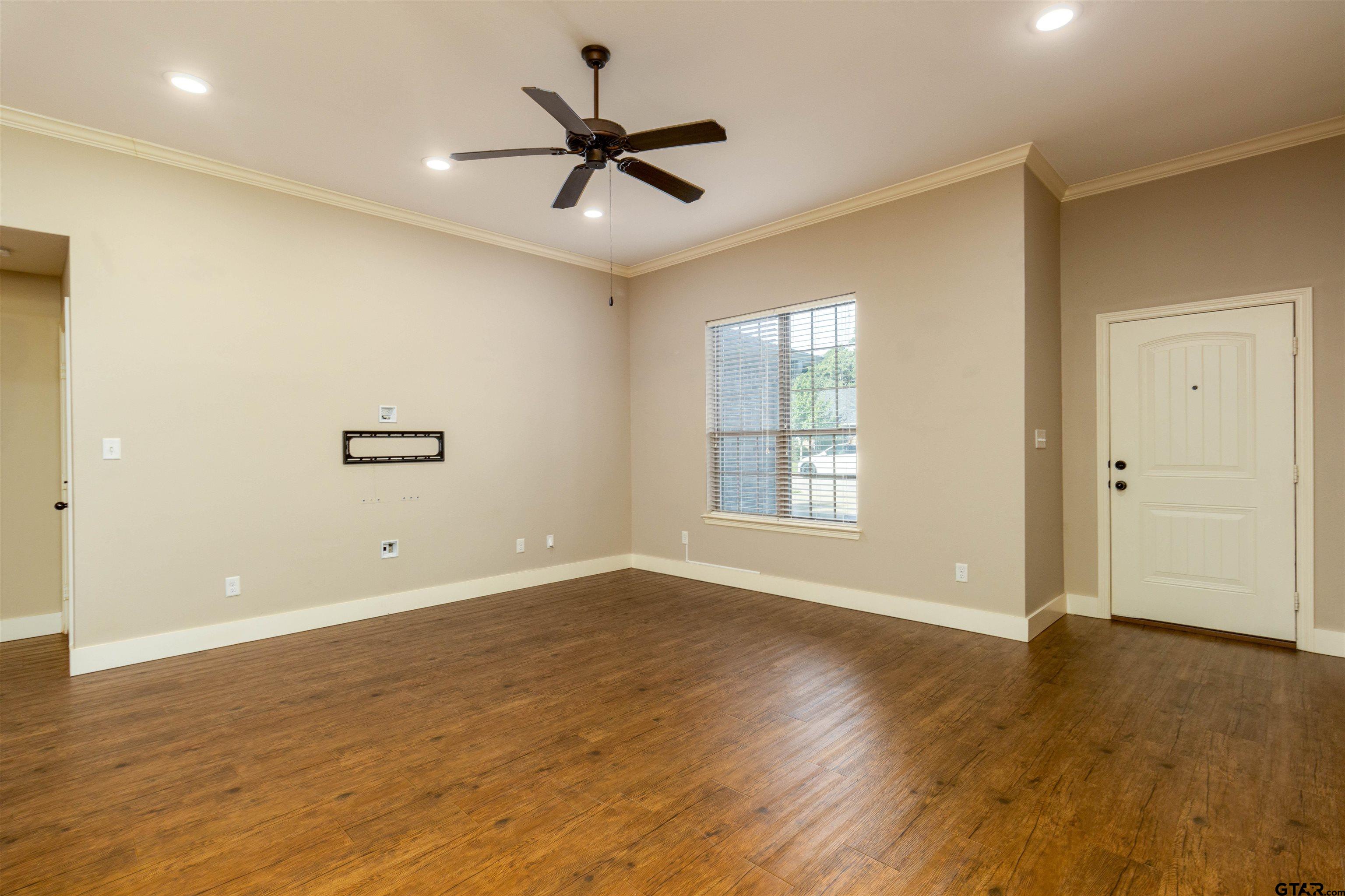 5106 Shiloh Ridge Drive Tyler, TX 75703 - Photo 5 of 19 a view of an empty room with wooden floor and a window