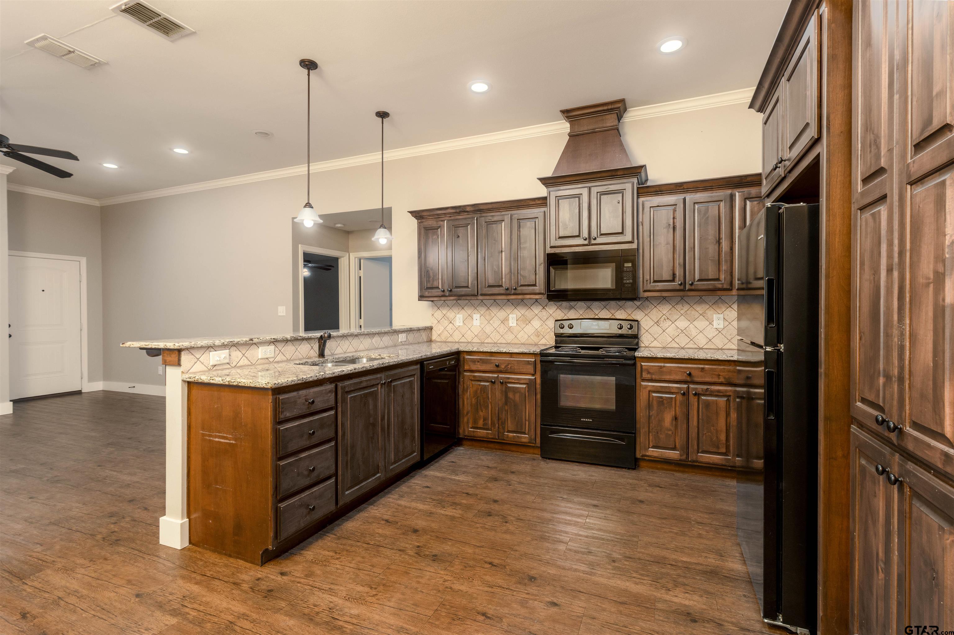 5106 Shiloh Ridge Drive Tyler, TX 75703 - Photo 7 of 19 a kitchen with granite countertop a stove and a refrigerator