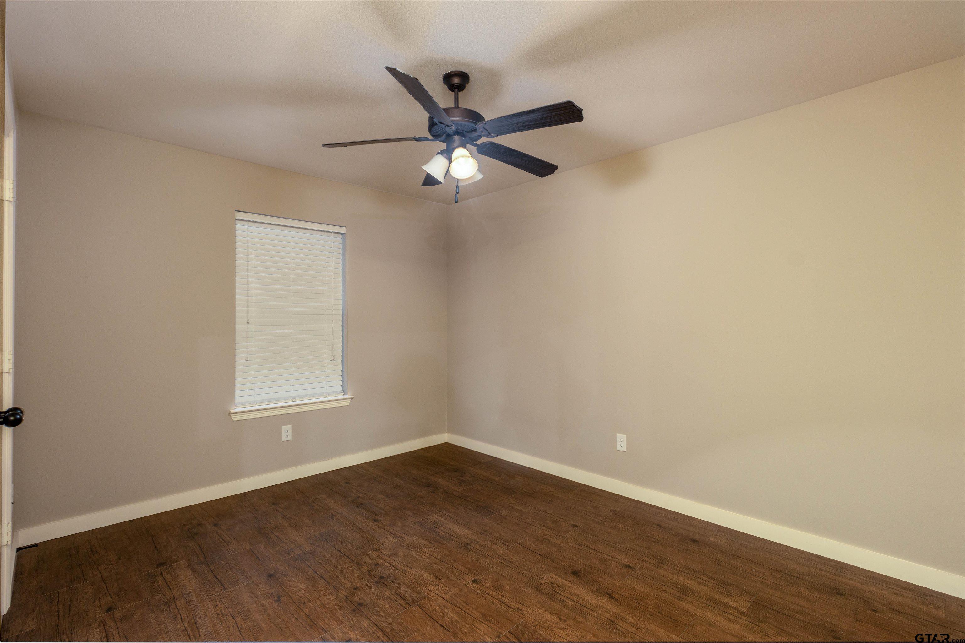 5106 Shiloh Ridge Drive Tyler, TX 75703 - Photo 9 of 19 an empty room with wooden floor fan and windows