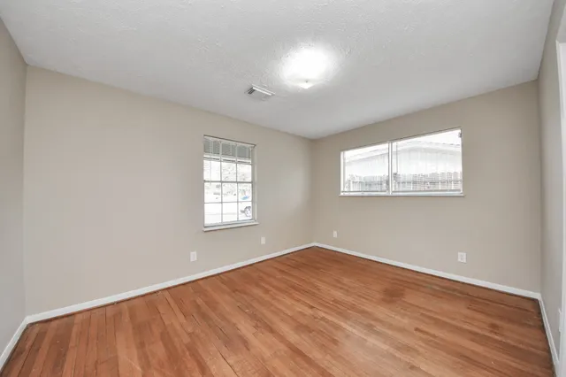 a view of an empty room with wooden floor